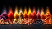 Vibrant spices and seasonings arranged in colorful waves with dramatic lighting, creating spectacular display of ground and whole spices against dark background.