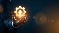 Businessman holding glowing gear with house symbol, representing smart home technology, real estate investment, and property management solutions for digital innovation.