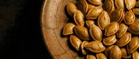 Roasted almonds in rustic wooden bowl on dark background. Healthy snacking, cooking ingredient for recipes, natural protein source for wellness lifestyle.