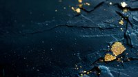 Scattered gold leaf flakes and particles on dark textured stone or slate background with dramatic lighting and copy space for luxury product photography.