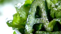 Fresh green lettuce leaf with water droplets in macro photography showing crisp texture and natural moisture on organic produce for food and healthy eating concepts.