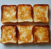 Six golden brown toasted bread slices arranged in two rows on white background, crispy texture perfect for breakfast menu design and culinary projects.