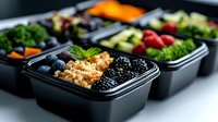 Fresh healthy meal prep containers with berries, quinoa, vegetables and fruits. Balanced lunch boxes for clean eating and portion control nutrition.