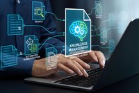 Professional hands typing on laptop with digital knowledge management system interface displaying interconnected documents and data processing icons.