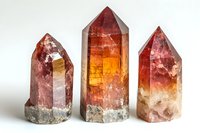 Red and orange crystal points with natural rough bases showcase vibrant color gradients and translucent surfaces against white background, suitable for wellness and spiritual designs.