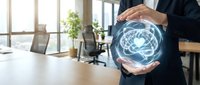Businessman protecting glowing brain hologram with hands in modern office workspace representing artificial intelligence and mental health concepts.