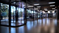 Empty modern office lobby with glass walls and illuminated elevator at night, reflecting lights on polished floor. Corporate building interior with minimalist design.