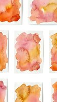 Abstract watercolor paint splatters in warm pink orange yellow tones on white paper texture for artistic design projects and creative backgrounds.