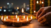 Hand lighting traditional oil lamps during festival celebration with warm glowing flames against blurred city lights background creating festive atmosphere.