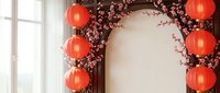 Traditional Chinese New Year decoration with red paper lanterns and cherry blossom branches creating festive arch for holiday celebration and cultural events.