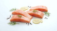 Fresh raw salmon fillets with dill herbs and lemon slices on white background, isolated seafood ingredients for cooking healthy omega-3 rich meals and recipes.