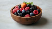 Fresh mixed berries including strawberry, raspberry, blackberry and blueberry in wooden bowl on light background, healthy organic summer fruit.