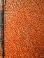 Close-up macro shot of genuine brown leather texture with visible grain pattern and stitching detail along edge, suitable for luxury product backgrounds.