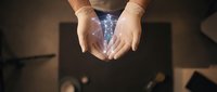 Hands cupped together holding glowing blue magical energy or light effect against dark background for fantasy and supernatural concepts.