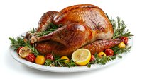Roasted whole turkey garnished with fresh rosemary, cherry tomatoes, lemon slices and garlic on white plate. Golden brown crispy skin and juicy meat for holiday dinner.