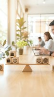 Wooden balance scale with business icons on cubes representing work-life balance and decision making in modern office environment.