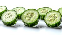 Fresh cucumber slices arranged in row showing inner texture and seeds on white background, macro food photography for healthy eating concepts.