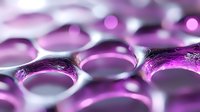 Purple water droplets on reflective surface creating abstract liquid pattern with soft focus bokeh effects for wellness and spa design concepts.
