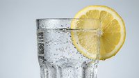 Refreshing sparkling water or soda with fresh lemon slice and ice cubes, perfect for beverage, food, and lifestyle advertising campaigns.