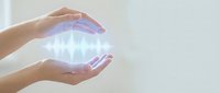 Hands cupping glowing energy sphere with magical light effects for healing, spirituality and wellness concepts.