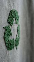 Green embroidered number three on natural linen fabric with shallow depth of field for textile and craft projects.