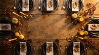 Autumn thanksgiving dinner table setting with plates, cutlery and seasonal decorations on rustic wooden background with copy space for text.