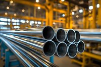 Steel pipes stacked in industrial warehouse with yellow structural supports and bokeh lighting, showing manufacturing and metallurgy production line.