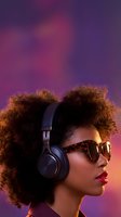 Stylish African American woman with afro hairstyle wearing headphones and sunglasses against vibrant purple gradient background for music and lifestyle content.