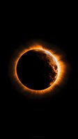 Solar eclipse with glowing orange corona ring against black space background, dramatic celestial phenomenon showing moon silhouette and sun's fiery edge.