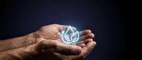 Male hand holding glowing blue water droplet symbol against dark background, representing clean energy, sustainability, environmental conservation, and eco-friendly technology solutions.