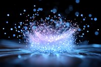 Magical splash of glowing blue and pink particles creating crown-like water effect on dark background with bokeh lights and rippling surface.