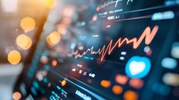 Stock market data visualization with glowing orange line graph on dark digital display screen showing financial analytics and trading statistics. Bokeh light effects.