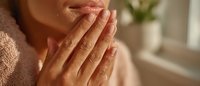 Woman with hands pressed together in prayer or meditation pose showing gratitude and mindfulness in warm natural light for wellness and spiritual content.