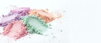 Colorful crushed makeup powder eyeshadow cosmetics scattered on white background for beauty and fashion design projects.