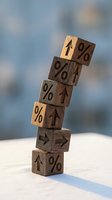 Wooden blocks stacked in a leaning tower with percent signs and arrows, symbolizing rising interest rates, inflation, or financial growth trends.