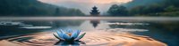 Serene blue lotus flower floating on rippling water surface at sunrise, with pagoda silhouette and misty mountains reflecting in tranquil lake.