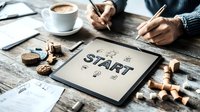 Business planning session with START text on tablet, coffee, wooden puzzle pieces and hands writing notes on rustic table.