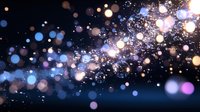 Magical glowing bokeh lights scattered on dark background with sparkles and blurred circles creating dreamy atmospheric effect. Perfect for festive designs.