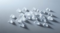 Clear diamond crystals scattered on neutral surface with dramatic shadows, suitable for luxury jewelry, gemstone, and high-end product marketing materials.