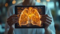 Digital tablet displaying glowing orange holographic lungs with anatomical details against blurred medical background, held by healthcare professional's hands.