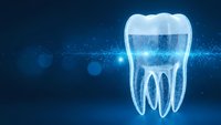 Glowing digital tooth hologram on blue technology background with particles and bokeh effects for dental healthcare and medical innovation concepts.