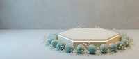 Elegant hexagonal mirror platform decorated with soft blue flowers and delicate lace trim for luxury product display and cosmetic photography.