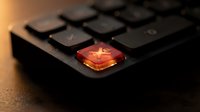 Red glowing keyboard key with warning symbol on black laptop computer for cybersecurity alerts and system notifications in technology workspace.