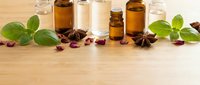 Natural essential oil bottles with herbs and spices on wooden background for aromatherapy wellness spa treatment and holistic healing remedies.