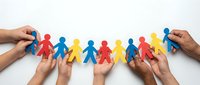 Diverse hands holding colorful paper cutout figures in red, blue, and yellow, representing unity, teamwork, community support, and inclusive collaboration for organizational and social concepts.