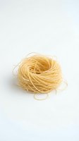 Coiled dried pasta nest isolated on white background, ready for food photography, cooking content, recipe design, and culinary illustrations.