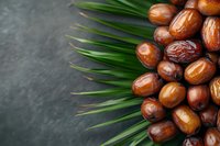 Fresh dates fruit with palm leaves on dark stone background for healthy eating and Middle Eastern cuisine recipes.