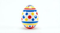 Colorful Easter egg with polka dots and stripes in red, blue, yellow colors isolated on white background for holiday decorations and spring celebrations.