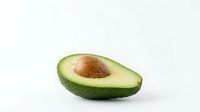 Fresh ripe avocado half with pit on white background, healthy organic fruit for cooking, nutrition and diet concepts.