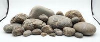 Collection of smooth river rocks and pebbles in various sizes arranged on white background for natural decoration and landscaping projects.